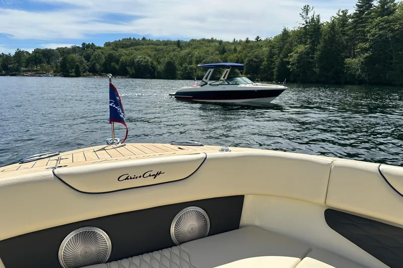 Slide: The Image of 2026 Chris-Craft Sportster 25 on a scenic lake with lush green trees. - 23