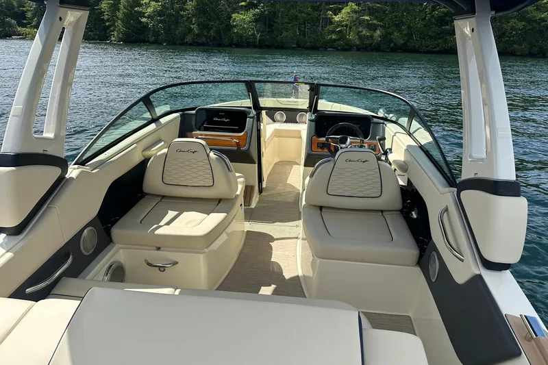 Slide: The Image of 2026 Chris-Craft Sportster 25 boat interior with luxurious seating on a serene lake. - 7