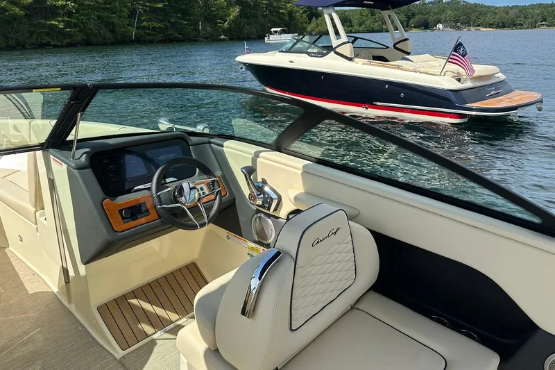Slide: The Image of 2026 Chris-Craft Sportster 25 interior with dashboard, steering wheel, and lake view. - 9