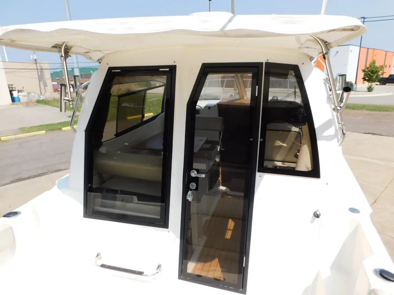 Slide: The Image of 2017 Cutwater C-24 boat with glass doors and canopy, docked outdoors. - 48