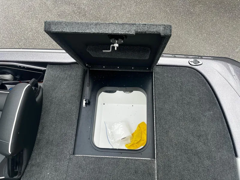 Slide: The Image of 2024 Skeeter ZXR 20 boat storage compartment with open lid, revealing interior space. - 12