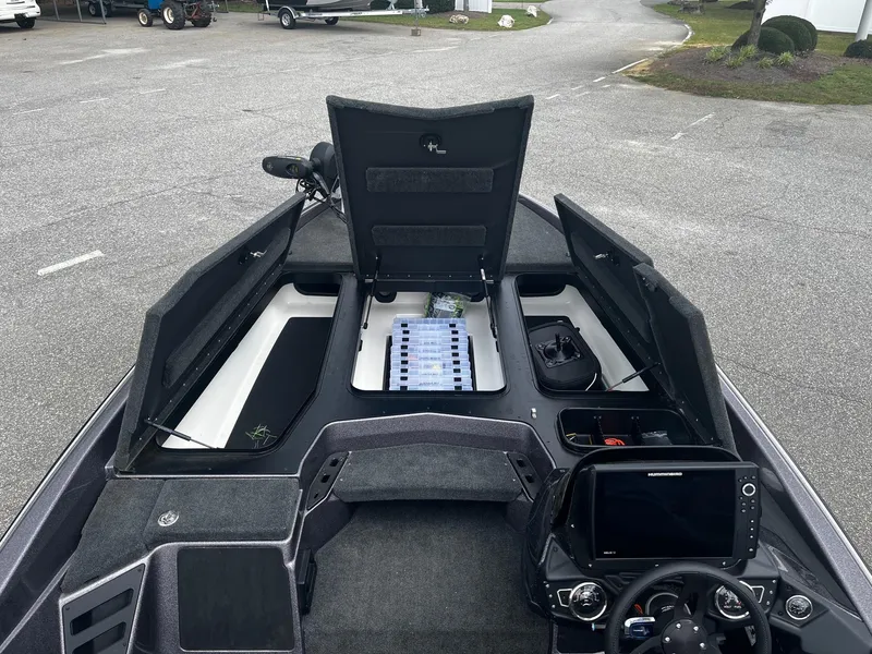 Slide: The Image of 2024 Skeeter ZXR 20 boat interior with open storage compartments and control panel. - 23