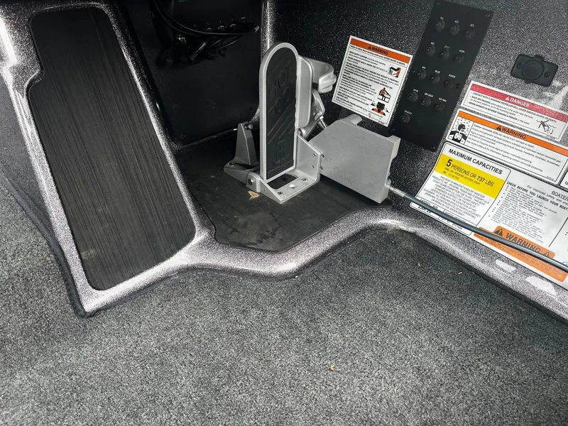 Slide: The Image of 2024 Skeeter ZXR 20 boat interior with foot pedal and warning labels. - 7
