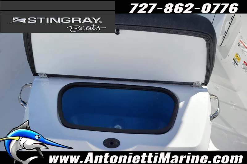 Slide: The Image of 2026 Stingray 173CC boat storage compartment open, featuring marine branding and contact details. - 8
