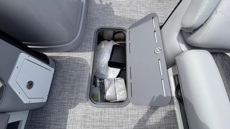 Slide: The Image of Storage compartment on 2025 JC Neptoon 25TT Sport boat, open with items inside. - 37