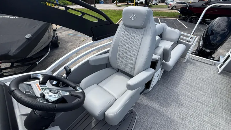 Slide: The Image of 2025 JC Neptoon 25TT Sport boat interior with luxury captain's chair and steering wheel. - 23