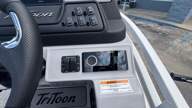 Slide: The Image of Control panel of 2025 JC Neptoon 25TT Sport boat with steering wheel and warning label. - 26