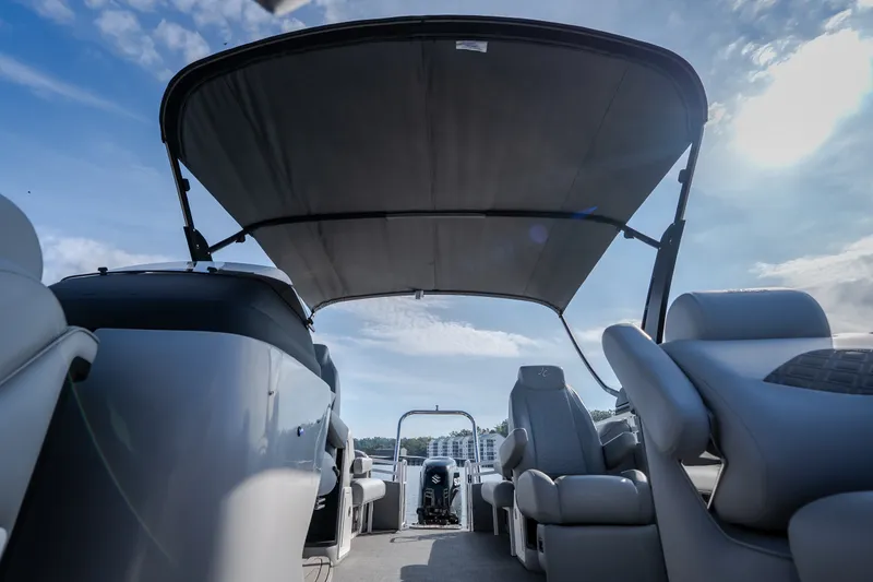 Slide: The Image of 2025 JC Neptoon 25TT Sport pontoon boat interior with canopy under blue sky. - 53