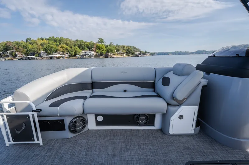 Slide: The Image of 2025 JC Neptoon 25TT Sport pontoon boat interior with plush seating on a scenic lake. - 38