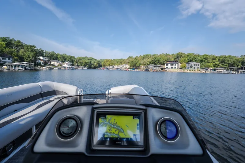 Slide: The Image of 2025 JC Neptoon 25TT Sport boat on a scenic lake with modern dashboard. - 13