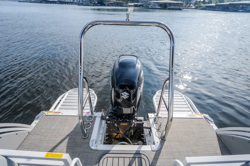 Slide: The Image of 2025 JC Neptoon 25TT Sport boat with outboard motor on a calm lake. - 25