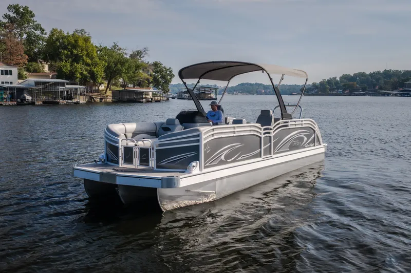 Slide: The Image of 2025 JC Neptoon 25TT Sport pontoon boat cruising on a serene lake. - 4