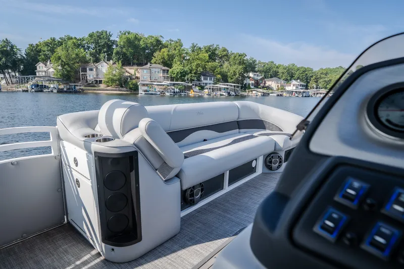 Slide: The Image of 2025 JC Neptoon 25TT Sport pontoon boat interior with luxurious seating on a scenic lake. - 36