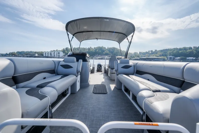 Slide: The Image of 2025 JC Neptoon 25TT Sport pontoon boat interior with spacious seating and canopy on a sunny day. - 45