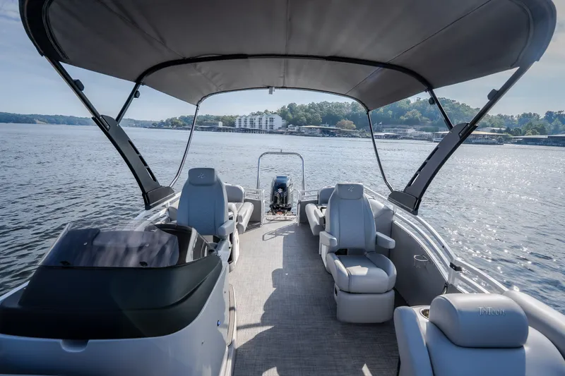 Slide: The Image of 2025 JC Neptoon 25TT Sport pontoon boat on a serene lake, featuring spacious seating. - 49