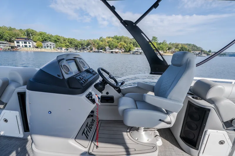 Slide: The Image of Helm of 2025 JC Neptoon 25TT Sport boat with luxurious seating and scenic lake view. - 16