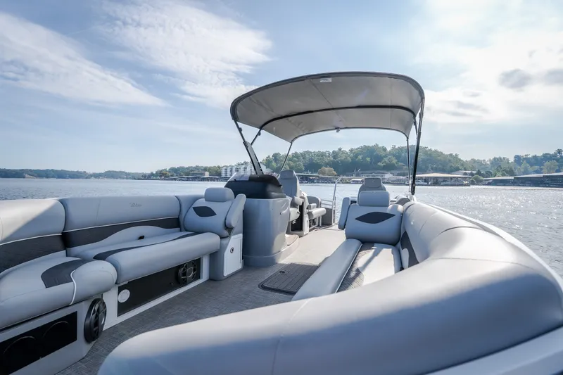 Slide: The Image of 2025 JC Neptoon 25TT Sport pontoon boat on a sunny lake, featuring spacious seating. - 44
