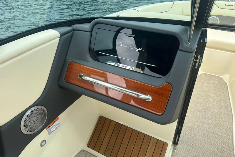 Slide: The Image of 2026 Chris-Craft Sportster 25 interior with wood accents and speaker detail. - 21