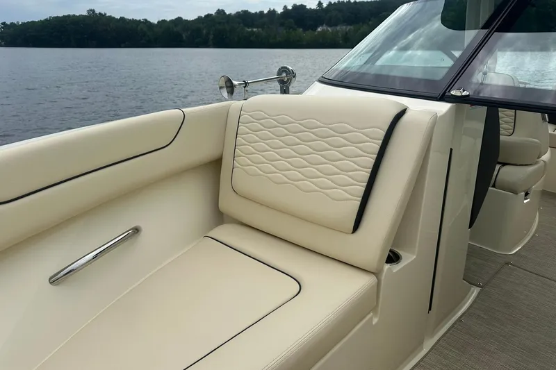 Slide: The Image of 2026 Chris-Craft Sportster 25 boat interior with elegant beige seating by the lake. - 27