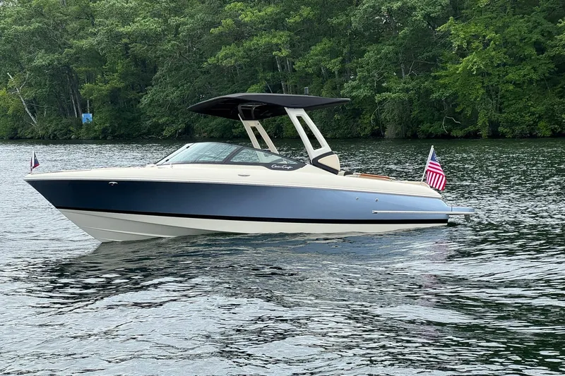 Slide: The Image of 2026 Chris-Craft Sportster 25 boat on a serene lake with lush green forest backdrop. - 3