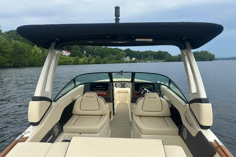 Slide: The Image of 2026 Chris-Craft Sportster 25 boat interior on a serene lake with lush greenery. - 16