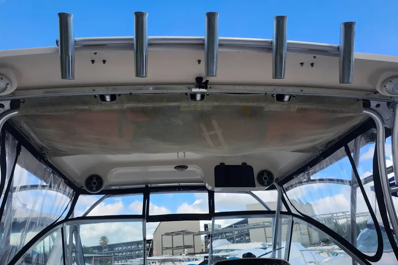 Slide: The Image of 2012 Grady-White Freedom 307 boat interior with rod holders and clear canopy. - 16