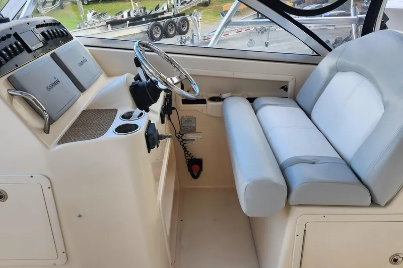 Slide: The Image of 2012 Grady-White Freedom 307 boat cockpit with steering wheel and Garmin navigation system. - 17