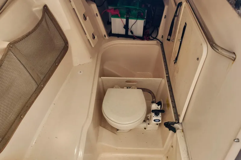 Slide: The Image of 2012 Grady-White Freedom 307 boat interior with marine toilet and storage compartment. - 24
