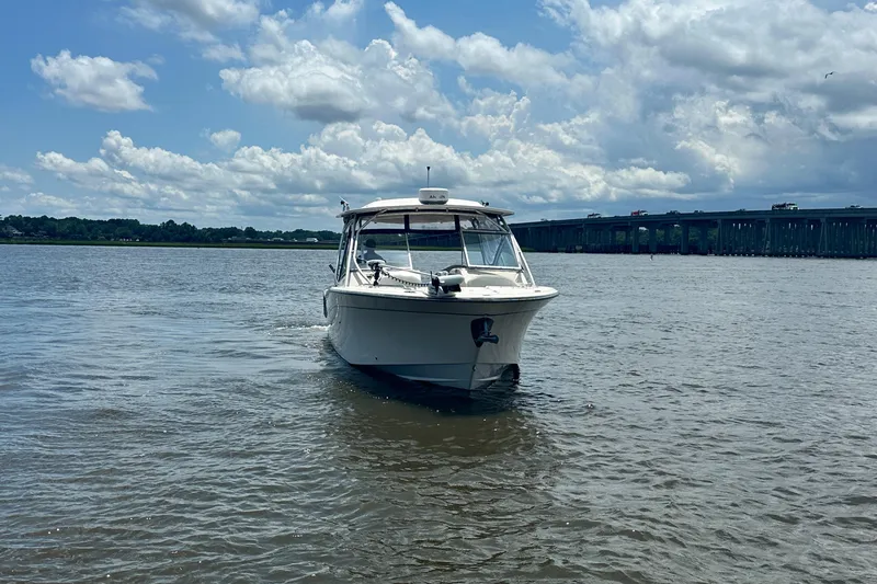 Slide: The Image of 2012 Grady-White Freedom 307 boat on a calm river under a cloudy sky. - 3