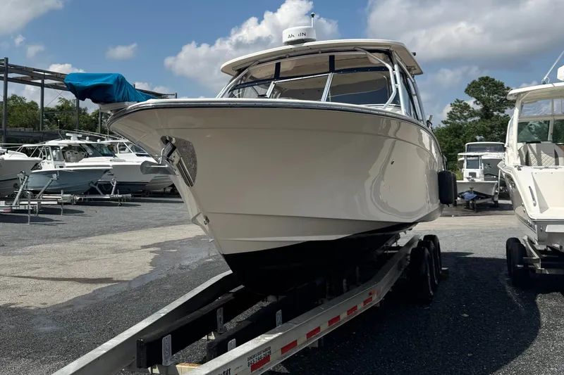 Slide: The Image of 2012 Grady-White Freedom 307 boat on trailer, parked in marina under cloudy sky. - 35