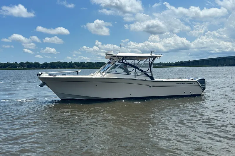Slide: The Image of 2012 Grady-White Freedom 307 boat on calm water under a partly cloudy sky. - 7