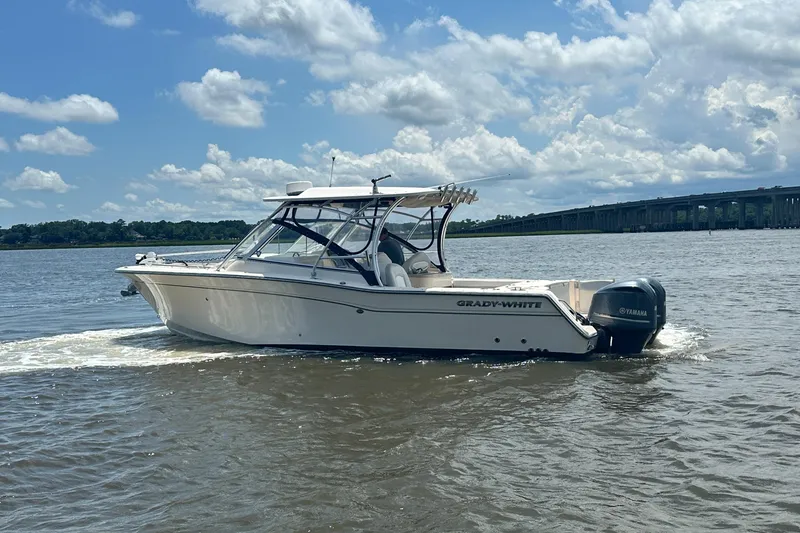 Slide: The Image of 2012 Grady-White Freedom 307 boat cruising on a sunny day with bridge in background. - 8