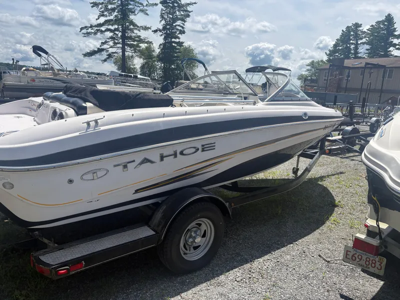 Slide: The Image of 2012 Tahoe Q5i boat on trailer, parked outdoors under a cloudy sky. - 2