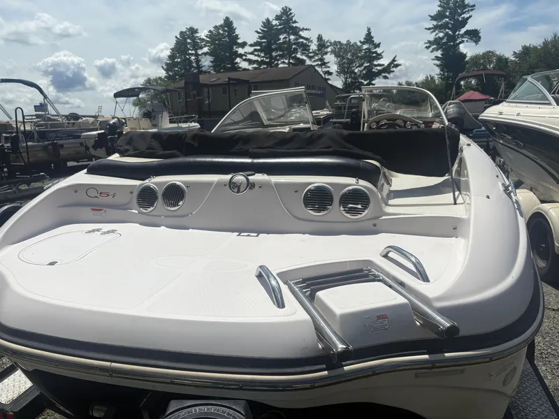 Slide: The Image of 2012 Tahoe Q5i boat with sleek design, parked among other boats under a partly cloudy sky. - 3