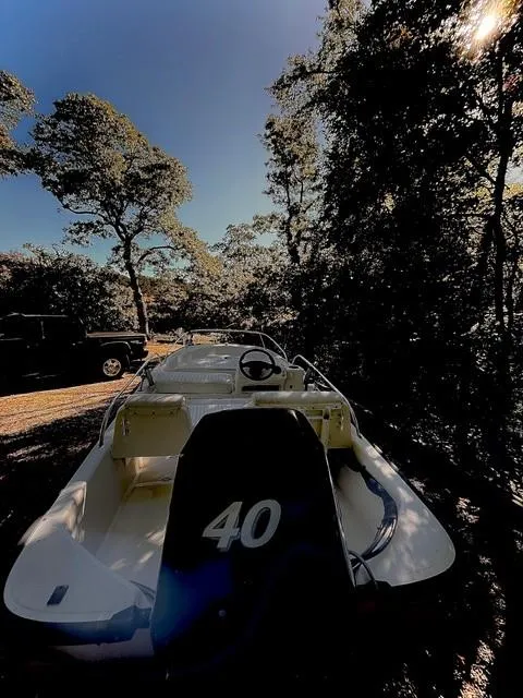 Slide: The Image of 2006 Boston Whaler 130 Sport boat in wooded area, sunlight filtering through trees. - 11