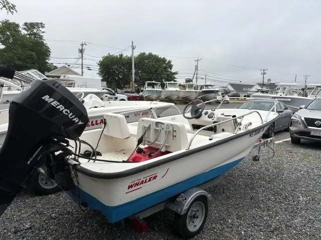 Slide: The Image of 2006 Boston Whaler 130 Sport boat with Mercury engine on trailer, parked outdoors. - 7