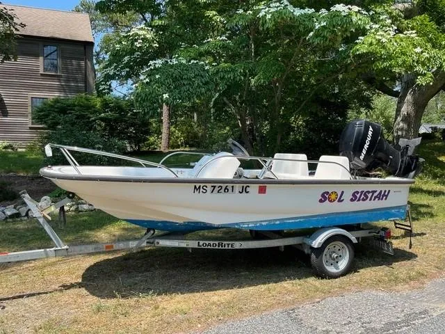 Slide: The Image of 2006 Boston Whaler 130 Sport boat on trailer, labeled "Sol Sistah," parked outdoors. - 8