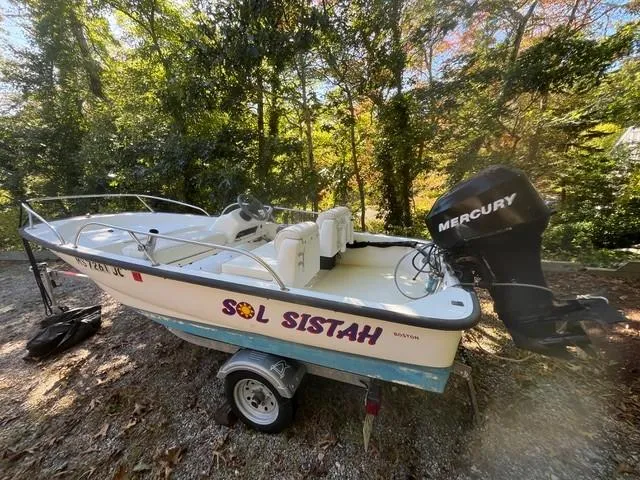 Slide: The Image of 2006 Boston Whaler 130 Sport boat with Mercury engine on a trailer in wooded area. - 9