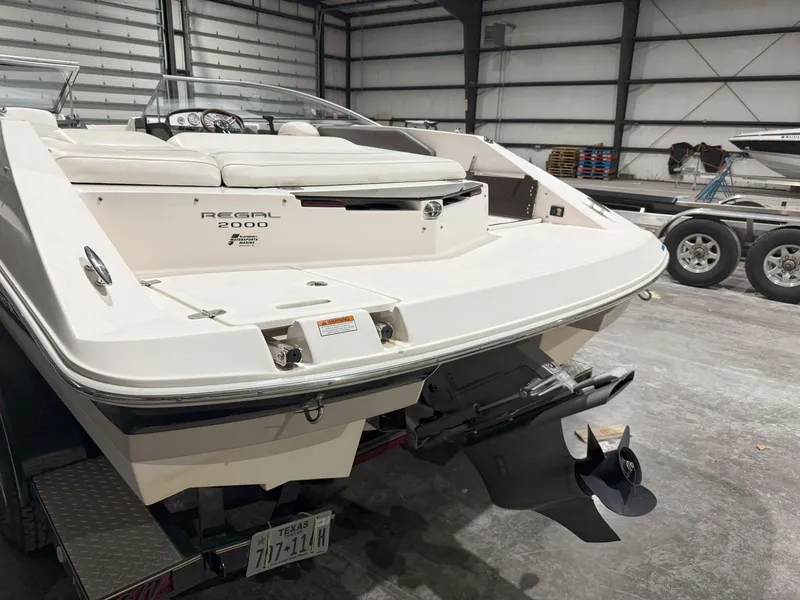 Slide: The Image of 2008 Regal 2000 Bowrider boat in a garage, showcasing rear view and propeller. - 8