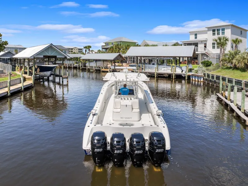 Slide: The Image of 2015 Yellowfin 39 boat with Mercury engines docked in a serene waterfront setting. - 12