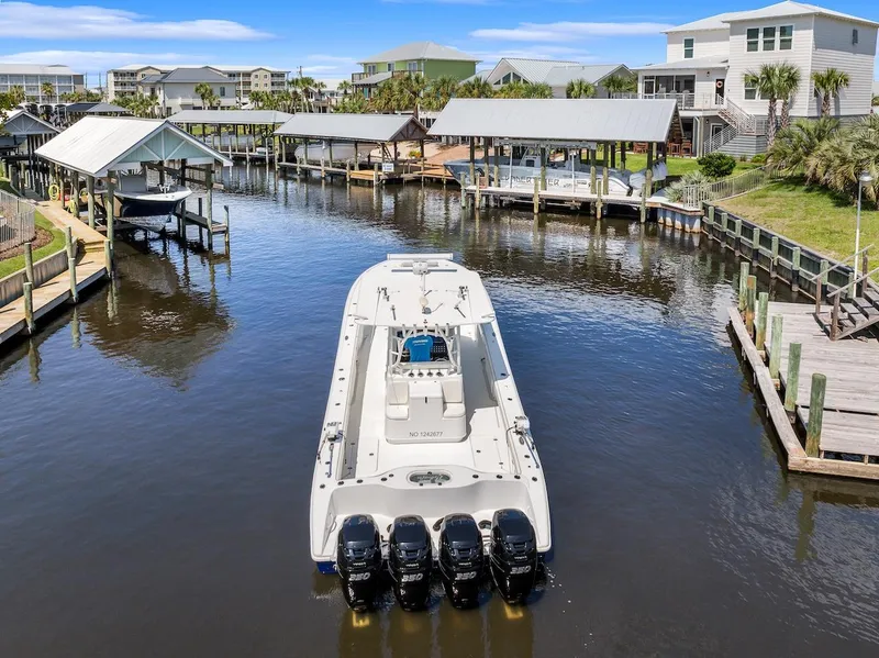 Slide: The Image of 2015 Yellowfin 39 boat docked in a scenic waterfront area with multiple outboard engines. - 13