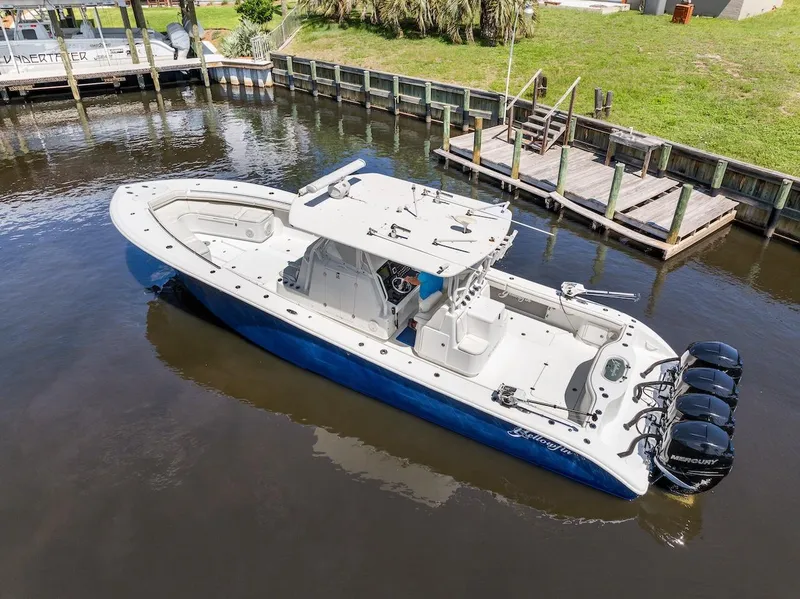 Slide: The Image of 2015 Yellowfin 39 boat docked in a scenic waterfront marina with multiple outboard engines. - 14