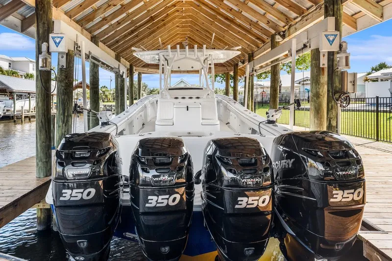 Slide: The Image of 2015 Yellowfin 39 boat with triple 350 engines docked under a wooden shelter. - 17