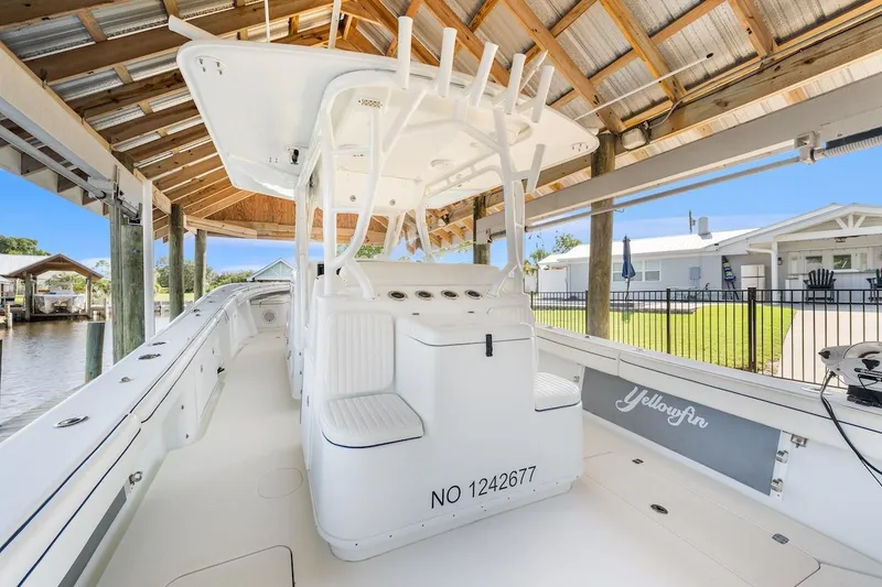 Slide: The Image of 2015 Yellowfin 39 boat under wooden shelter, featuring sleek white design and advanced equipment. - 20
