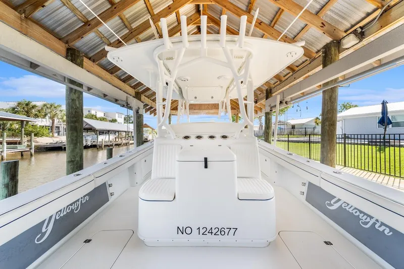 Slide: The Image of 2015 Yellowfin 39 boat docked under a wooden canopy, showcasing sleek design and spacious deck. - 21