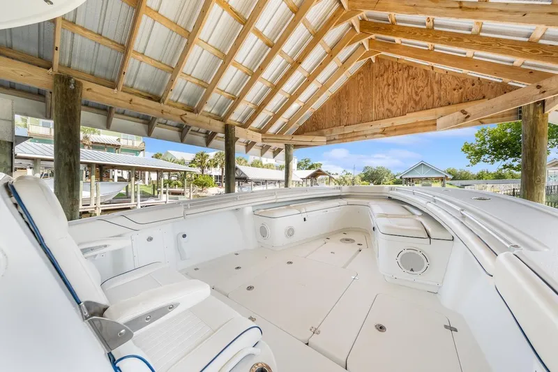 Slide: The Image of 2015 Yellowfin 39 boat interior with white seating, docked under a wooden shelter. - 25