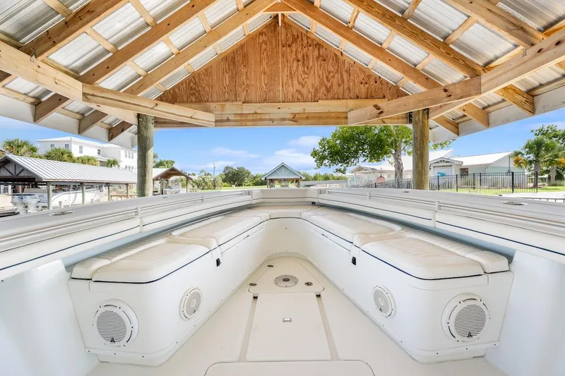 Slide: The Image of 2015 Yellowfin 39 boat under wooden shelter, showcasing spacious seating and sleek design. - 26