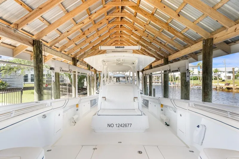 Slide: The Image of 2015 Yellowfin 39 boat interior under wooden canopy, featuring cushioned seating and speakers. - 27