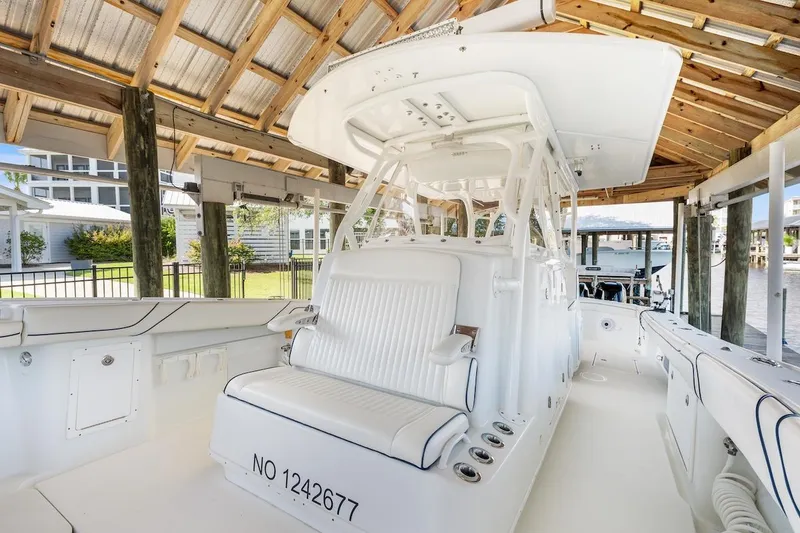 Slide: The Image of 2015 Yellowfin 39 boat docked under wooden shelter, featuring spacious seating and sleek design. - 29