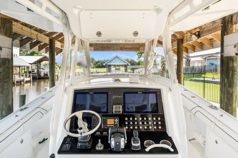 Slide: The Image of 2015 Yellowfin 39 boat cockpit with advanced navigation system, docked in a serene marina setting. - 36